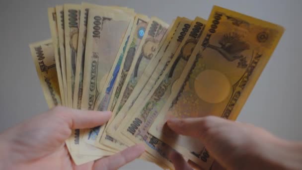 Ditembak Tangan Seseorang Memegang Beberapa Uang Kertas Jepang Dan Menghitungnya — Stok Video