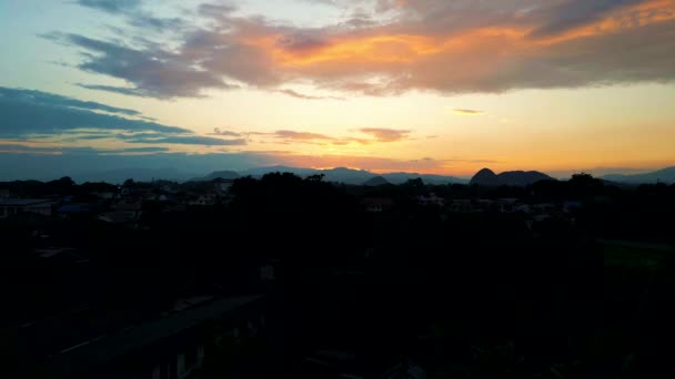 美しい日没の間に山に面したタイのチェンライ市を飛行する無人機の4Kシネマティックな自然空撮 — ストック動画