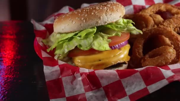 Czerwone Niebieskie Światło Odbija Się Czarnego Blatu Stołu Kosz Cheeseburger — Wideo stockowe