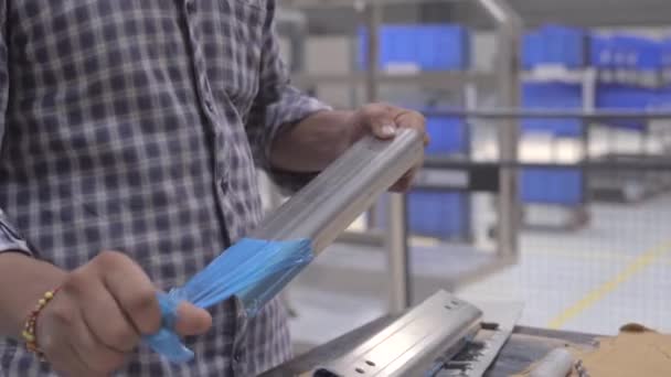 Ένας Άνθρωπος Αφαιρώντας Πλαστικό Κάλυμμα Του Προϊόντος Από Ανοξείδωτο Χάλυβα — Αρχείο Βίντεο