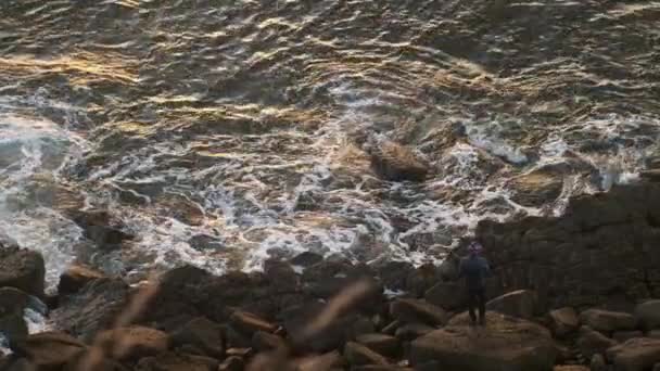 Mavi Deniz Önündeki Kayalıklarda Sabırla Bekleyen Balıkçı Görüntüsü — Stok video
