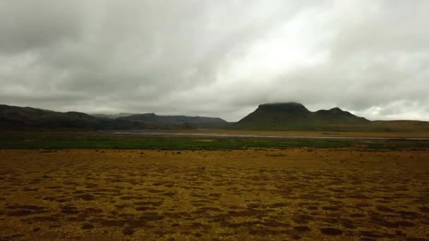 冰岛一条冰川河流在山谷中流淌 在黑暗的沙滩上的空中景观 — 图库视频影像