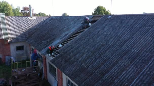 Drei Männer Reparieren Das Alte Asbestschieferdach Des Bauernhauses — Stockvideo