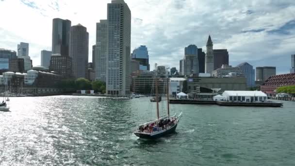 ボストン港のタールシップ セイルボート 風にアメリカの旗の波 都市景観スカイラインビュー — ストック動画