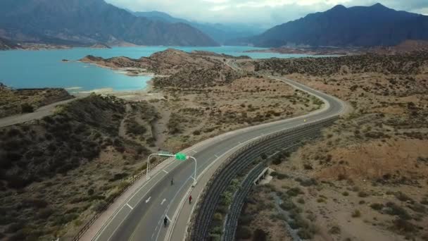 Cyklisté Silnici Malebným Výhledem Modrou Řeku Obklopenou Horami Embalse Potrerillos — Stock video