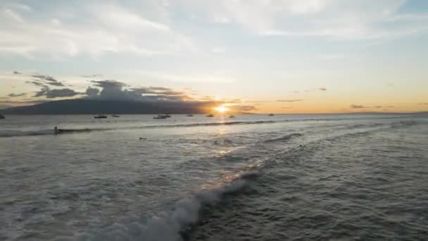 太陽はラナイ島の後ろに沈み 固定されたボートはラハイナ波のサーファーの鞭として — ストック動画