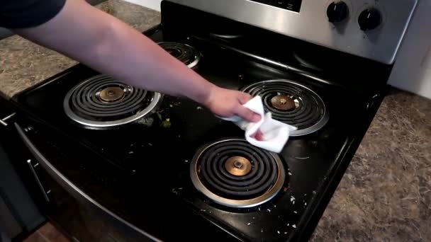 用纸巾把剩余的食物放在肮脏的黑炉子上擦拭 — 图库视频影像