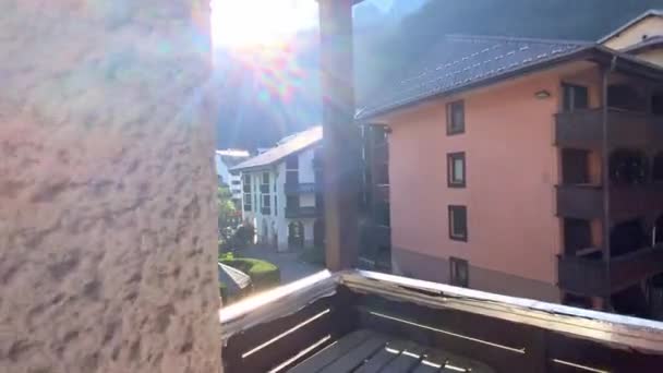 日当たりの良い朝にフランスのシャモニーにあるアパートメントビルのバルコニーからのパノラマの山の風景 ドリー ショット — ストック動画