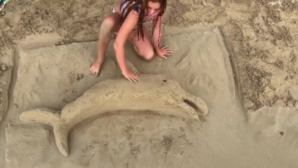 可爱的红头发小女孩跪在沙滩上玩沙滩上的海豚 假日和夏季概念 — 图库视频影像