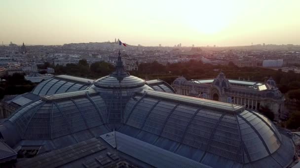 パリの街を背景に美しいプチパレを特徴とするガラス窓を通して反射する太陽と朝のグランドパリの航空ツアー — ストック動画