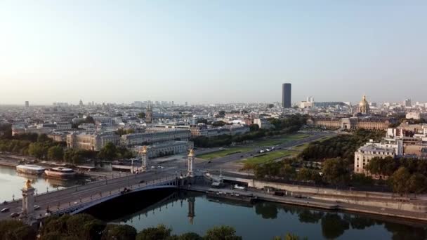 ホテル ローヌのドローンツアーは 日の出時にグランド パレから川を渡り モンパルナスタワーを背景にしたポンアレクサンドル3世 をフィーチャーしています — ストック動画