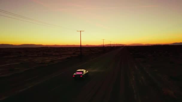 無人機などで砂漠の道を走るピンク色の内装車 — ストック動画