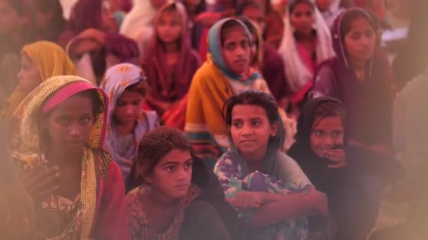 パキスタンの農村部の学校の教室でマットに座っている彼らの頭の上にDupattaと多くの小さな女の子のビデオ — ストック動画