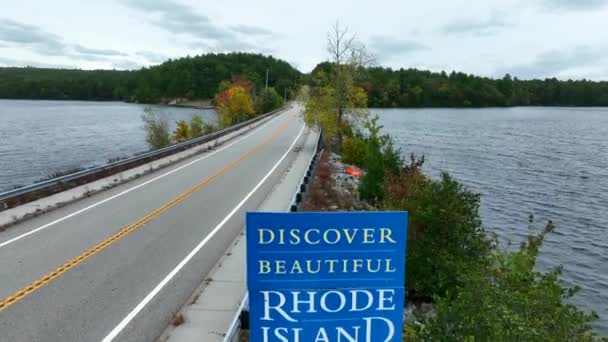 ロードアイランド州の標識へようこそ 秋に国境と美しい湖に沿って空中上昇 — ストック動画