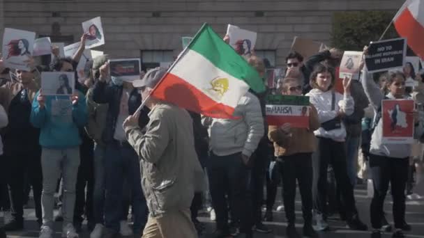 現在の抑圧的なイラン政権に抗議してイラン国旗を掲げて歩く男 — ストック動画