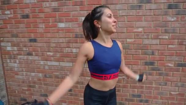 Спортивная Активная Латиноамериканка Занимающаяся Прыжками Разогревается Перед Кирпичной Стеной — стоковое видео