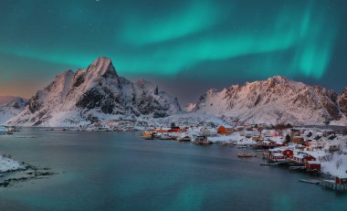 Kuzey Işıklı Reine kasabasının dramatik akşam manzarası. Reinefjorden sahilinde kırmızı ajanlar var. Lofotens 'ta popüler bir seyahat yeri. Konum: Reine, Lofoten; Norveç, Avrupa