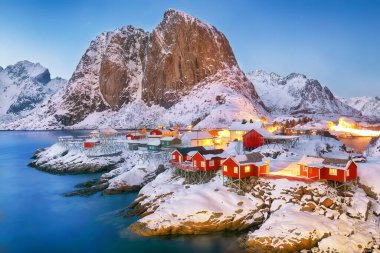 Arka planda Hamnoy Köyü ve Festhaeltinden Dağı 'nın muhteşem kış manzarası. Lofotens 'ta popüler bir turizm merkezi. Konum: Hamnoy, Moskenesoya, Lofoten; Norveç, Avrupa