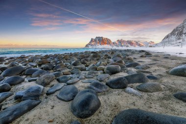 Gün batımında Uttakleiv sahilindeki şaşırtıcı kış manzarası. Popüler turizm merkezi. Konum: Vestvagoy Adası, Lofoten; Norveç, Avrupa