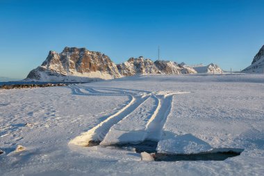 Uttakleiv sahilinde sabah araba raylarıyla muhteşem bir kış manzarası. Popüler turizm merkezi. Konum: Vestvagoy Adası, Lofoten; Norveç, Avrupa