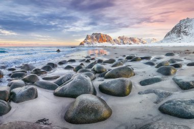 Gün batımında Uttakleiv sahilindeki şaşırtıcı kış manzarası. Popüler turizm merkezi. Konum: Vestvagoy Adası, Lofoten; Norveç, Avrupa