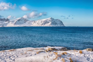 Picturesque winter view on Flakstad coastline seen from the oposite side in the morning. Popular tourist destination. Location: Flakstadoya island, Lofoten; Norway, Europe