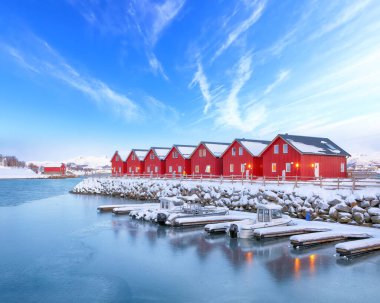 Gorgeous scenery wit traditional red wooden houses on the shore of Offersoystraumen fjord. Popular travel destination on Lofotens. Location: Vestvagoy island, Lofoten; Norway, Europe