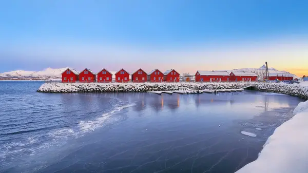 Gorgeous scenery wit traditional red wooden houses on the shore of Offersoystraumen fjord. Popular travel destination on Lofotens. Location: Vestvagoy island, Lofoten; Norway, Europe