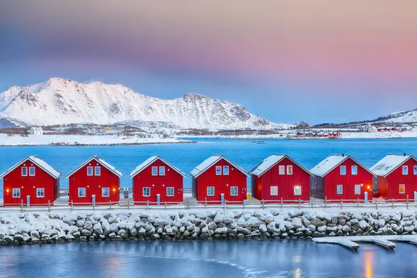 Gorgeous scenery wit traditional red wooden houses on the shore of Offersoystraumen fjord. Popular travel destination on Lofotens. Location: Vestvagoy island, Lofoten; Norway, Europe