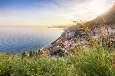 Awesome sunset and seascape near Taormina resorts and Etna volcano mount. Giardini-Naxos bay, Ionian sea coast, Taormina, Sicily, Italy.