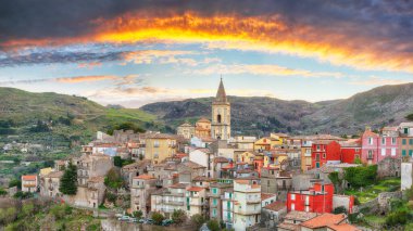 Amazing Panorama of the belltower and the village in the valley at sunset. Mountain village Novara di Sicilia, Sicily, Italy