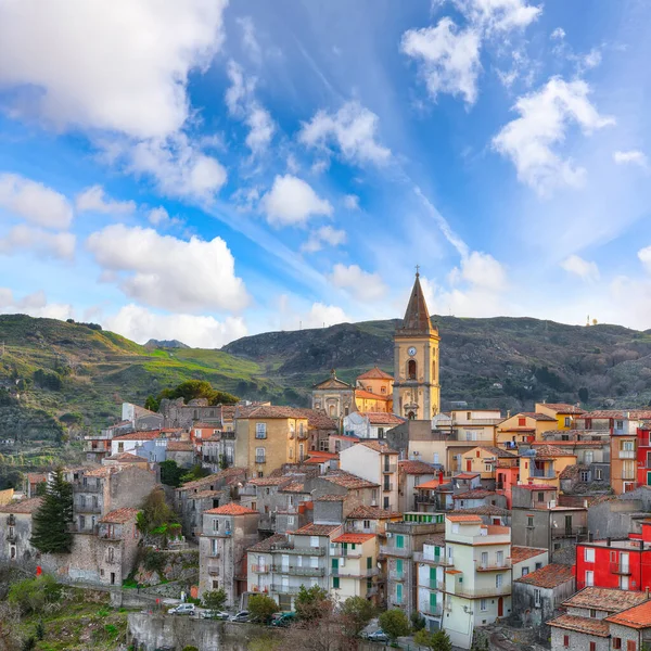 Amazing Panorama of the belltower and the village in the valley at early sunrise. Mountain village Novara di Sicilia, Sicily, Italy