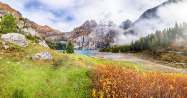 Oeschinensee Gölü 'nün muhteşem sonbahar manzarası. Arka planda Bluemlisalp zirvesi olan İsviçre Alpleri sahnesi. Konum: Oeschinen Vadisi, Bern Kantonu, İsviçre, Avrupa