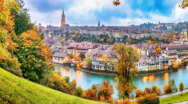 Fabulous autumn view of Bern city on Aare river during evening with Cathedral of Bern on background. Location: Bern, Canton of Bern, Switzerland, Europe