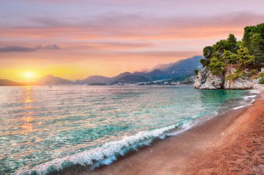 Budva yakınlarındaki Sveti Stefan adası yakınlarındaki lüks plajın büyüleyici günbatımı manzarası. Konum: Budva Riviera, Karadağ, Balkanlar, Adriyatik denizi, Avrupa