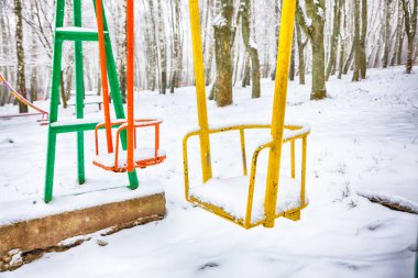 Boş salıncak ile kar kış zamanında. Kar kalın bir tabaka altında çocuk salıncak