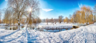Karlı ağaçlarla çarpıcı bir manzara, suda yansıması olan güzel donmuş bir nehir. Kış manzarası