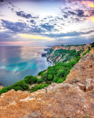 Cape Fiolent 'te büyüleyici bir günbatımı çalılar ve kayalar ön planda. Konum: Kırım, Pelerin Fiolent