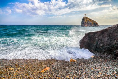 Deniz dalgalarının kıyıya çarpması ve deniz çakıl taşlarının üzerinde akışının inanılmaz görüntüsü. Kaya sahili.