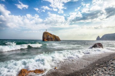 Deniz dalgalarının kıyıya çarpması ve deniz çakıl taşlarının üzerinde akışının inanılmaz görüntüsü. Yeri: Jasper Sahili, Cape Fiolent, Kırım