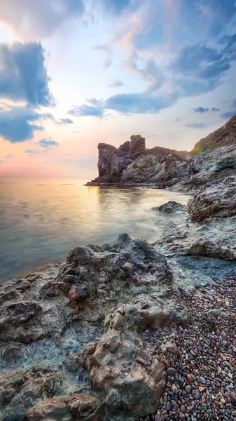 Gün batımında inanılmaz deniz manzarası. Uzun vadede güzel bir deniz manzarası. Önplanda taşlar