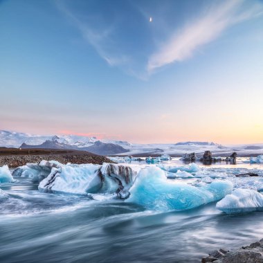 Gün batımında Jokulsarlon Buzul Gölü 'nde yüzen buzdağlarıyla muhteşem bir manzara. Konum: Jokulsarlon Buzul Gölü, Vatnajokull Ulusal Parkı, Güney İzlanda, Avrupa