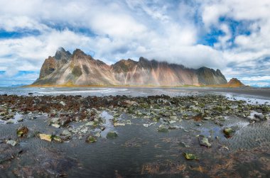İnanılmaz güneşli bir gün ve İzlanda 'daki Stoksnes Burnu' nda dramatik bir kara kum plajı. Konum: Stoksnes Pelerini, Vestrahorn (Batman Dağı), İzlanda, Avrupa.