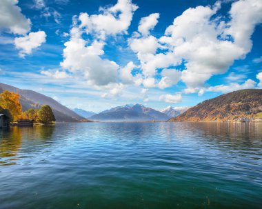 Sell Am See 'deki göl ve ağaçların olağanüstü sonbahar manzarası. Gölün üzerinde güneşli harika bir gün.