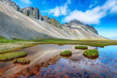 İnanılmaz güneşli bir gün ve İzlanda 'daki Stokkksnes Burnu' nda Vestrahorn Dağı yakınlarında muhteşem bir çayır. Konum: Stoksnes Pelerini, Vestrahorn (Batman Dağı), İzlanda, Avrupa.