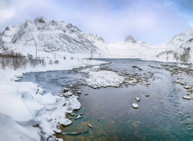 Lofoten Adaları 'nda karlı dağ zirveleri olan Vestvagoy Adası' nda Kartfjorden 'in dramatik kış manzarası. Konum: Vestvagoy, Kartfjorden, Lofoten Adaları, Norveç, Avrupa.