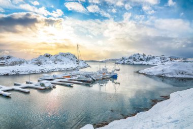 Amazing winter scenery with yachts and boats nier pier in small fishing village and snowy  mountain peaks near Valberg.  Location: Valberg, Vestvagoy, Lofotens, Norway
