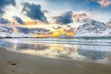 Gün batımında Vik sahilinin muhteşem kış manzarası. Leknes yakınlarında bir sürü kar ve karlı dağ tepeleri var. Konum: Leknes, Vestvagoy, Lofotens, Norveç
