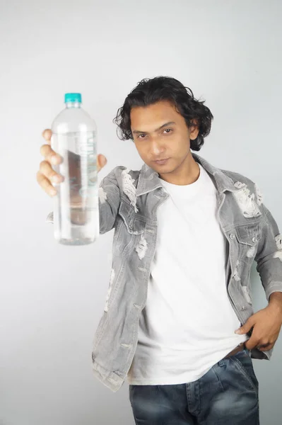 Cool attitude man holding water bottle over background