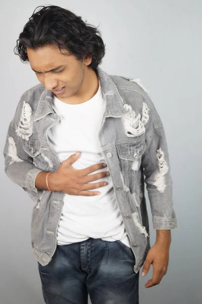 Young man having abdomen pain over white background